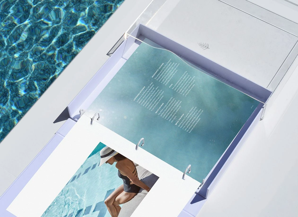 Open Four Seasons Residential welcome compendium displayed in a clear acrylic slip case, showing interior pages with photography and text beside a pool.