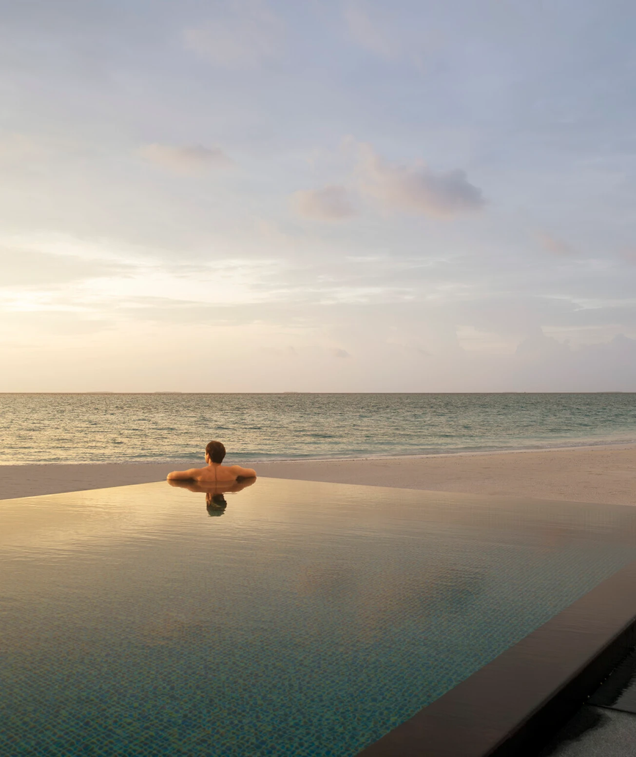 Ambient property shot of a person in an infinity pool