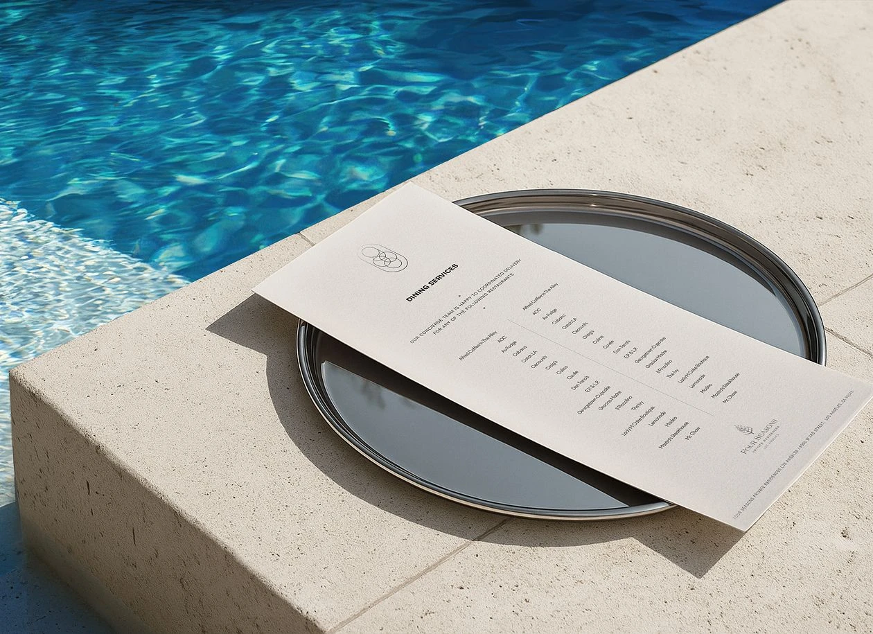 Four Seasons Los Angeles Residential printed collateral displayed poolside on a mirrored tray.