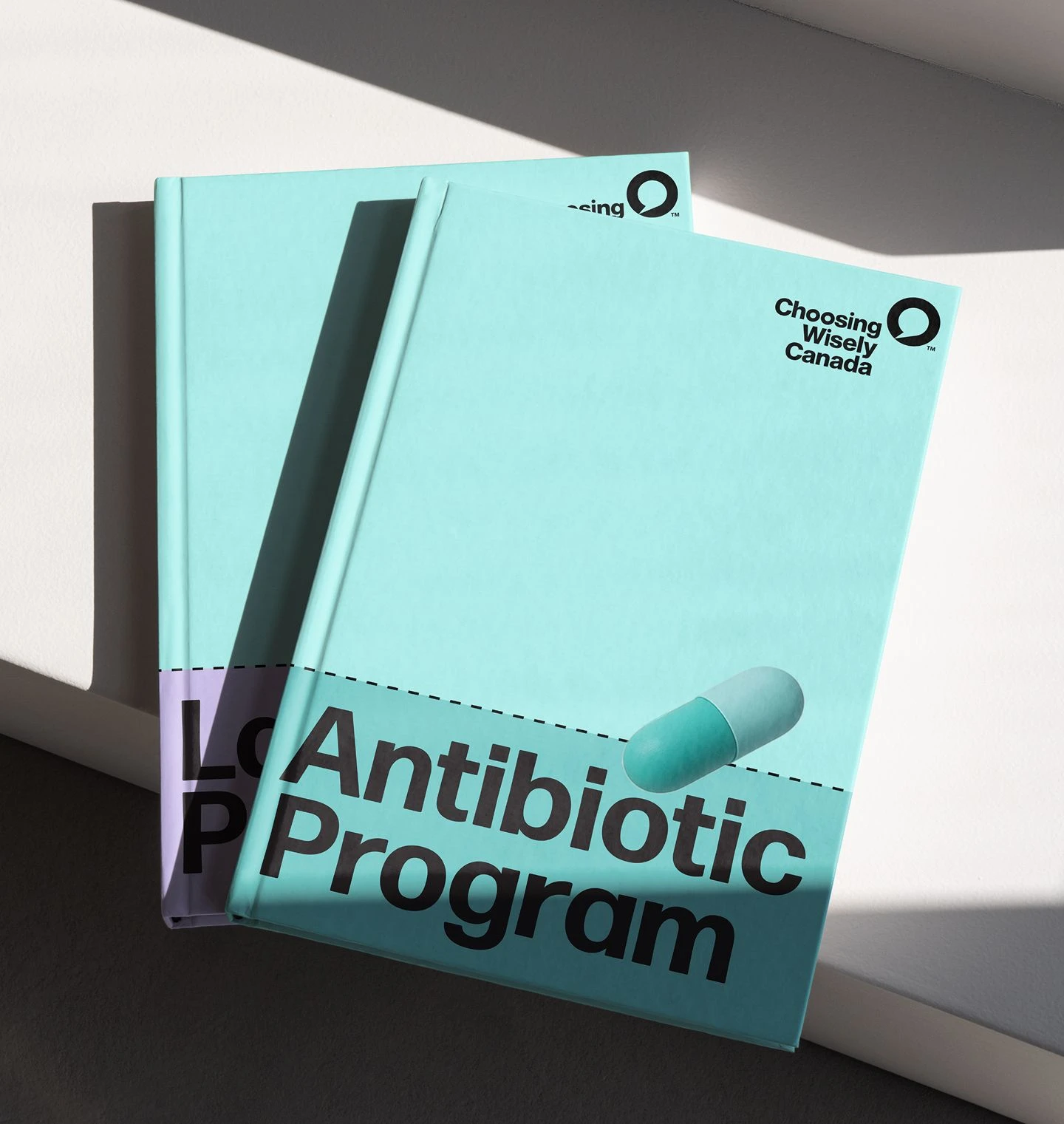Choosing Wisely Canada print design showing an ‘Antibiotic Program’ booklet with bold typography and pill icon
